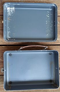 Zwei leere graue Metallschalen auf Holzuntergrund