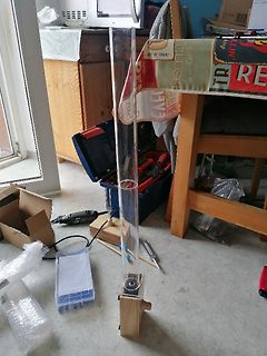 Versuchsaufbau mit Glaszylinder auf Holzsockel