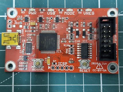 Rote Leiterplatte mit Mikrocontroller und Bauteilen