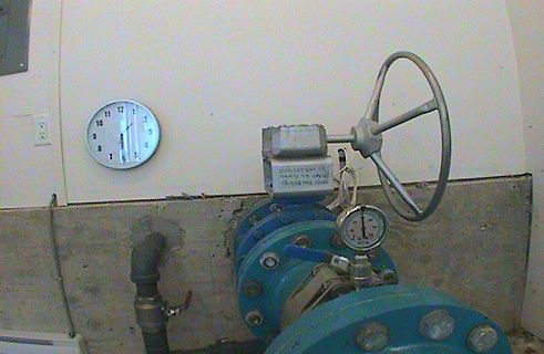 Ventil mit Manometer und Uhr an Wand
