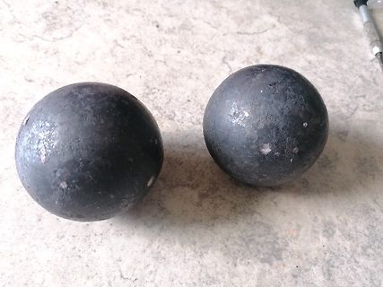 Zwei dunkle Metallkugeln auf hellem Untergrund