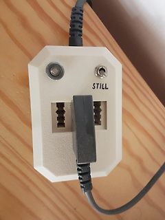 Steckdose mit eingestecktem Netzteil auf Holzuntergrund