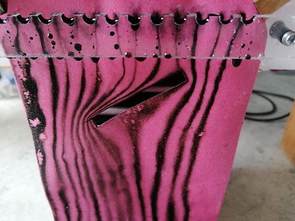 Nahaufnahme einer pinkfarbenen Oberfläche mit schwarzen Streifen