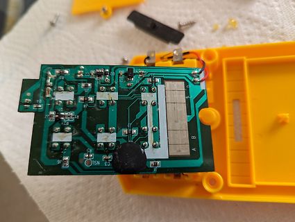Geöffnete Elektronik mit Leiterplatte und gelbem Gehäuse