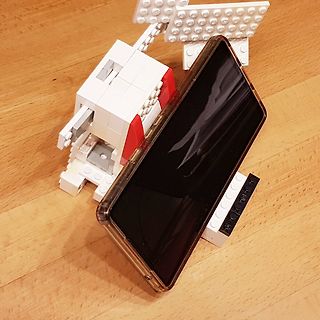 Smartphone in LEGO-Halterung auf Holztisch