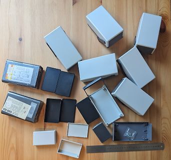 Verschiedene Kunststoffgehäuse und Verpackung auf Holzuntergrund