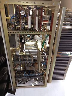 Innenansicht eines alten elektronischen Geräts mit mechanischen Bauteilen