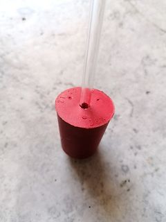 Roter Gummistopfen mit Schlauchanschluss