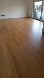 Leerer Raum mit Holzboden und Balkontür