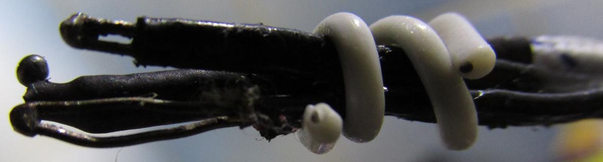 Makroaufnahme von Drähten und weißem Silikon oder Klebstoff
