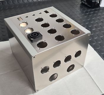 Metallgehäuse mit vielen runden Aussparungen und einem Anschluss