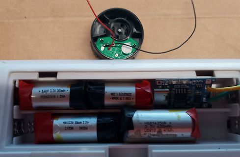 Geöffnetes Batteriefach mit Akkus und kleiner Platine