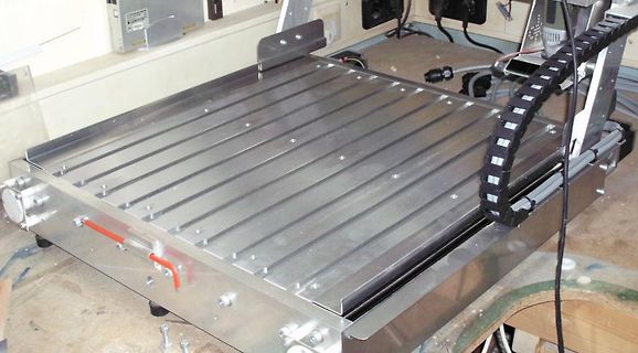 Metallische Arbeitsfläche oder CNC-Tisch mit Kabelkette