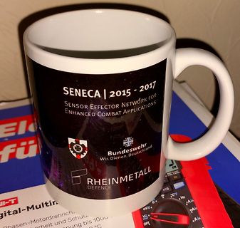 Bedruckter weißer Becher mit Projektlogo