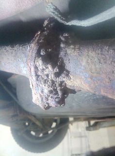 Stark korrodierte Metallteile unter einem Fahrzeug