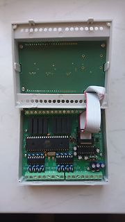 Geöffnetes Gehäuse mit Mikrocontroller-Platine und Flachbandkabel