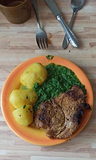 Teller mit Fleisch, Kartoffeln und Spinat