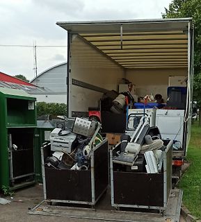 Elektroschrott in Containern und einem Transporter