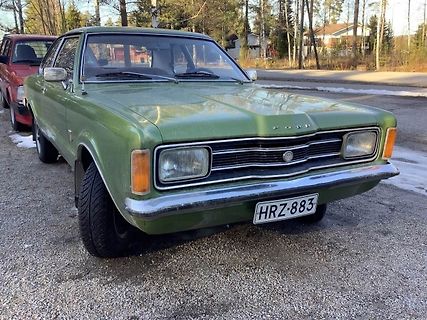 Grüner Oldtimer auf Schotterplatz