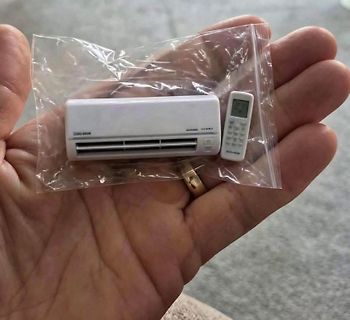 Miniatur Klimaanlage und Fernbedienung in Plastikbeutel