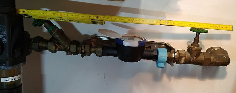 Wasserzähler mit Rohranschlüssen und Maßband