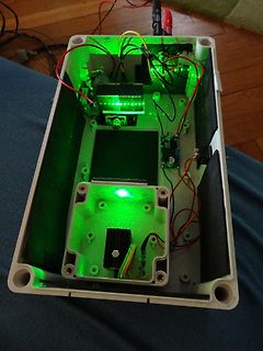 Innenansicht eines Gehäuses mit Elektronikkomponenten und grüner LED-Beleuchtung