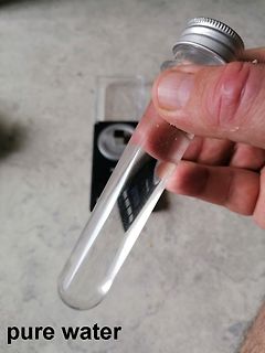 Hand hält ein Reagenzglas mit Flüssigkeit
