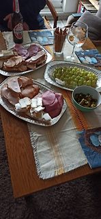 Platte mit Aufschnitt, Käse, Weintrauben und Oliven