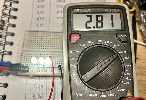 Multimeter und Breadboard mit leuchtenden LEDs