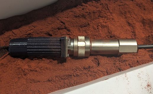 Sensor in rötlichem Pulver oder Sand