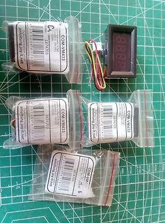 Vier COM-VM433 Voltmeter in Plastikverpackung und ein Display
