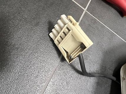 Elektrischer Stecker mit Kabel auf Fliesenboden