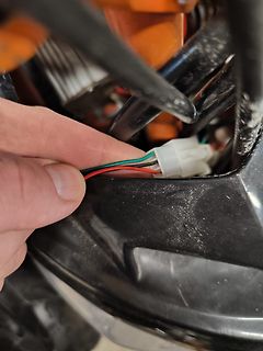 Hand hält elektrischen Stecker mit Kabeln