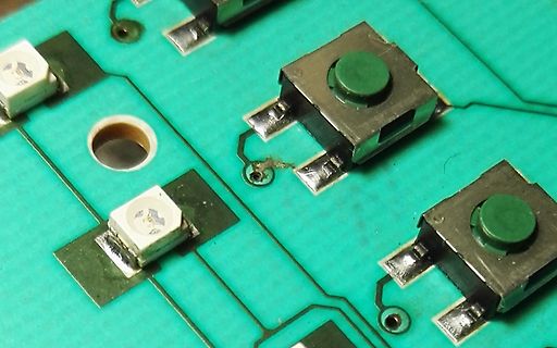 Nahaufnahme einer Leiterplatte mit Taster und SMD-Bauteilen