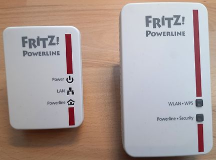 Zwei FRITZ! Powerline Adapter auf Holzuntergrund