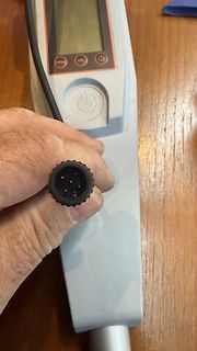 Hand hält Stecker eines Messgeräts