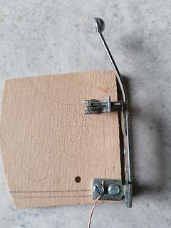 Mechanische Halterung mit Metallbügel auf Holzbrett