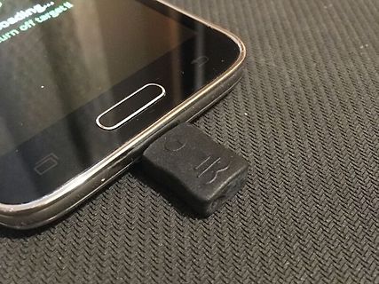 Smartphone und kleiner schwarzer USB-Dongle