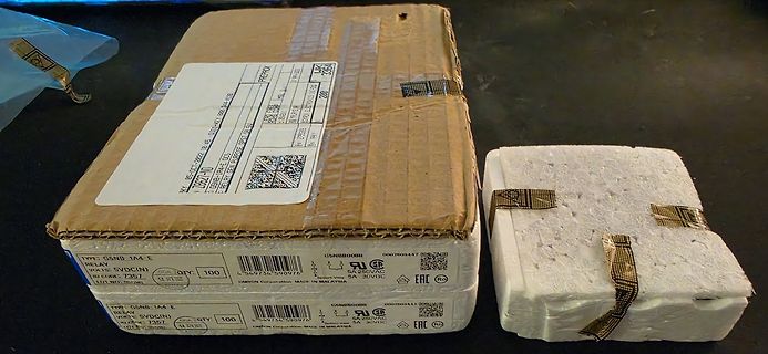 Versandkarton und Styroporverpackung mit Relais-Etiketten