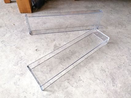 Zwei transparente Kunststoffboxen auf einem Boden