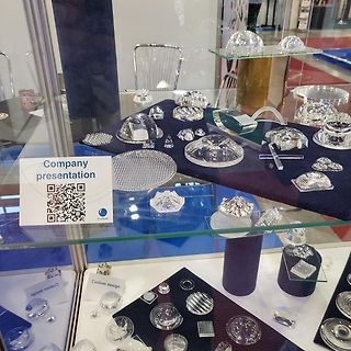 Glasobjekte in einer Vitrine mit Firmenpräsentation