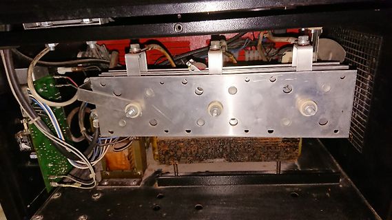 Innenansicht eines elektronischen Geräts mit Metallplatte und Kabeln