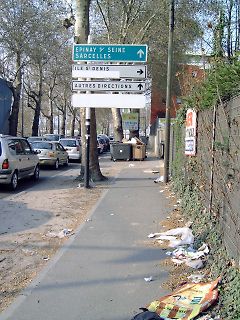 Straßenschild und Parkplatz mit Müll