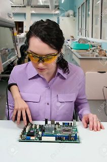 Technikerin untersucht Leiterplatte in Werkstatt