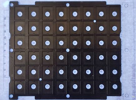 Matrix aus kleinen runden Öffnungen auf dunklem Untergrund