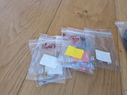 Mehrere Beutel mit elektronischen Bauteilen auf Holzuntergrund