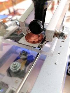Nahaufnahme eines mechanischen Aufbaus mit Münze als Maßstab