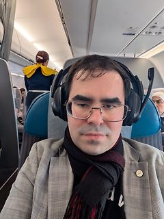 Mann mit Kopfhörern im Flugzeug