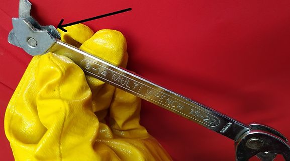Hand mit gelbem Handschuh hält einen Multi-Wrench