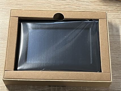 Verpackung eines schwarzen Objekts auf Holztisch